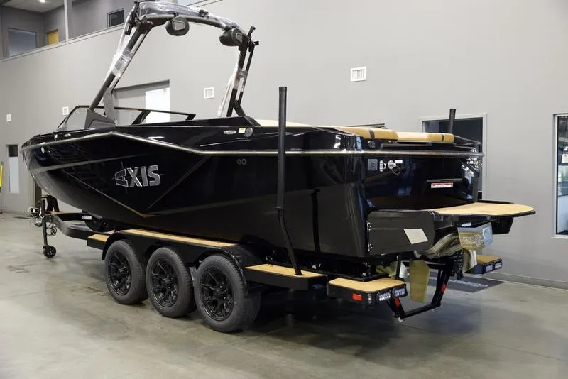 Slide: The Image of 2025 Axis T250 boat on trailer in showroom, sleek black design. - 5