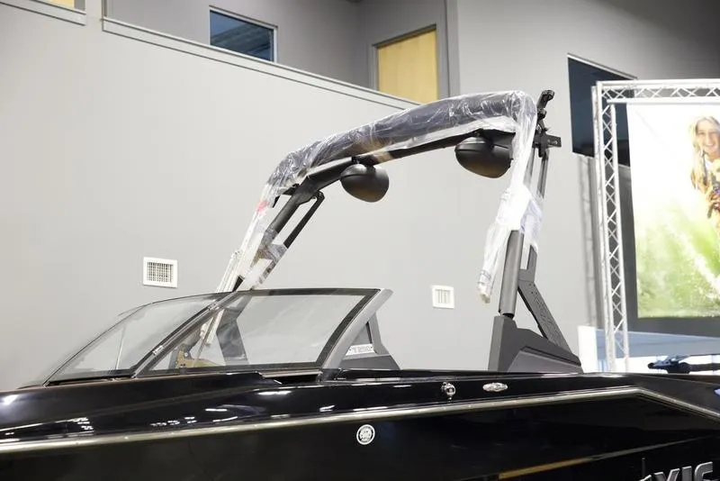 Slide: The Image of 2025 Axis T250 boat with sleek black design and modern features in showroom. - 6