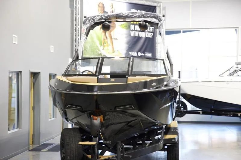 Slide: The Image of 2025 Axis T250 boat displayed indoors on a trailer. - 7
