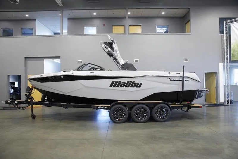Slide: The Image of 2025 Malibu 25 LSV boat on trailer in showroom. - 1
