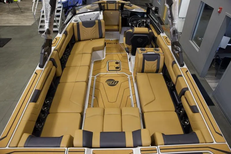 Slide: The Image of 2025 Malibu 25 LSV boat interior with tan and black seating, spacious layout. - 12