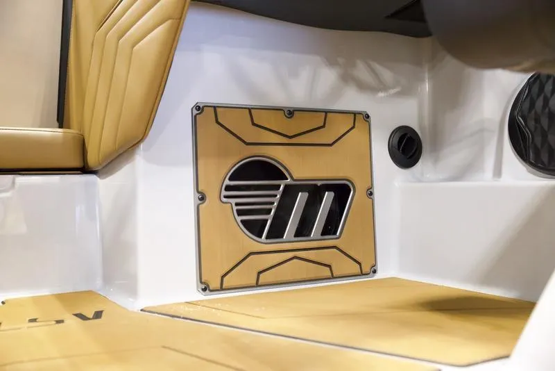 Slide: The Image of 2025 Malibu 25 LSV interior with stylish tan seating and custom speaker panel. - 16