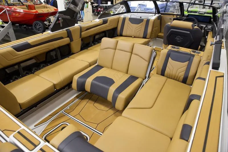 Slide: The Image of Luxurious interior of 2025 Malibu 25 LSV boat with tan and black seating. - 19