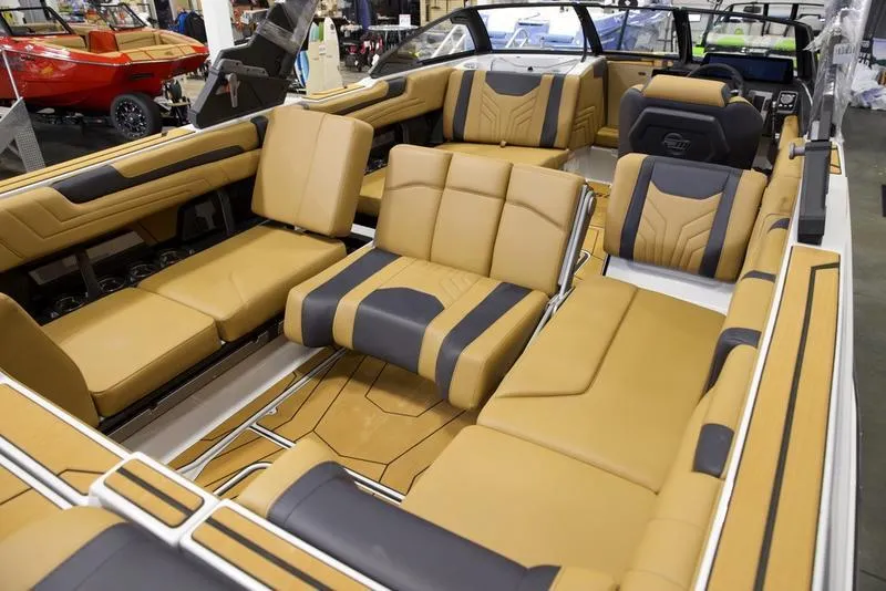 Slide: The Image of 2025 Malibu 25 LSV boat interior with luxurious tan and black seating. - 21