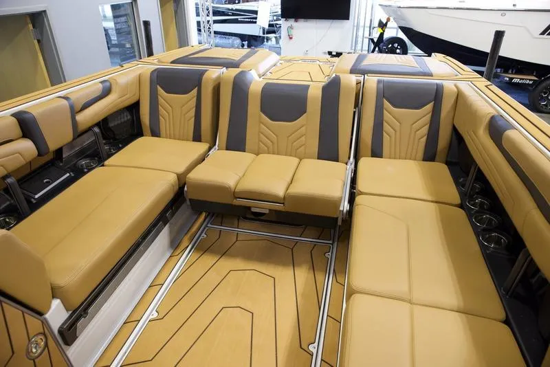 Slide: The Image of Luxurious interior of 2025 Malibu 25 LSV boat with tan and gray seating. - 25