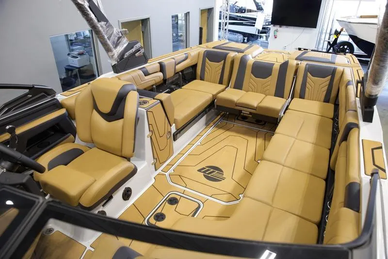Slide: The Image of Luxurious interior of 2025 Malibu 25 LSV boat with tan and black seating. - 28