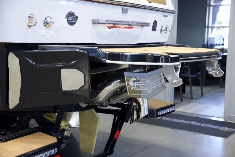 Slide: The Image of 2025 Malibu 25 LSV boat rear view with swim platform and exhaust system. - 6
