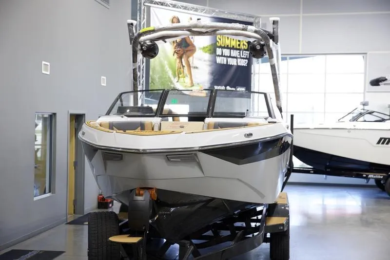 Slide: The Image of 2025 Malibu 25 LSV boat displayed indoors on a trailer. - 9