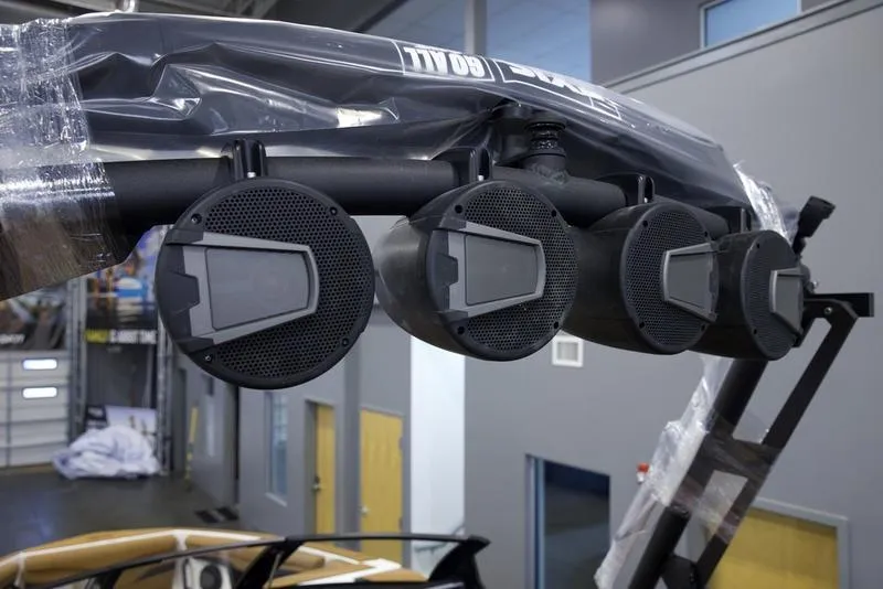 Slide: The Image of 2025 Axis T250 boat speakers mounted on a wakeboard tower in a showroom. - 11