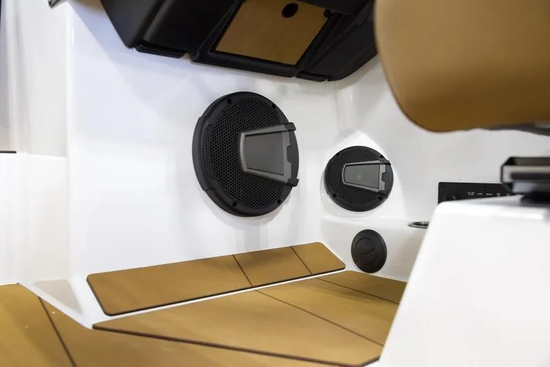 Slide: The Image of 2025 Axis T250 boat interior with speakers and tan seating. - 13
