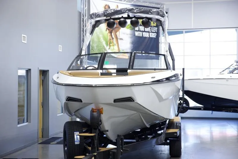 Slide: The Image of 2025 Axis T250 boat displayed indoors on a trailer. - 8