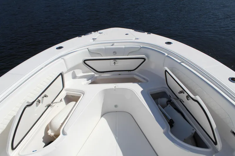 Slide: The Image of 2019 Edgewater 370CC boat deck with open storage compartments on calm water. - 17
