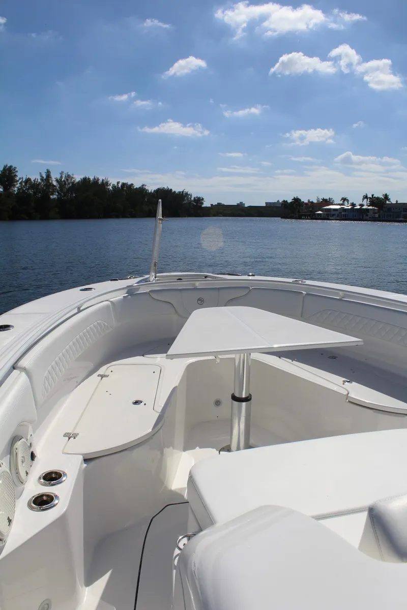 Slide: The Image of 2019 Edgewater 370CC boat on calm water under blue sky. - 18