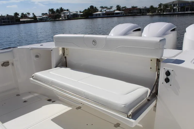 Slide: The Image of 2019 Edgewater 370CC boat with foldable white bench seat by the water. - 25