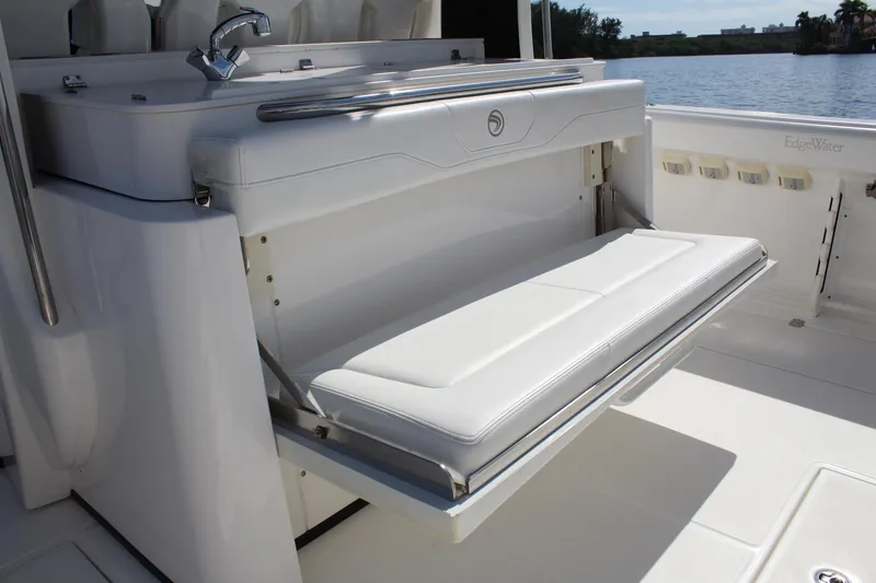 Slide: The Image of 2019 Edgewater 370CC boat with fold-out seating and sink, docked by the water. - 28