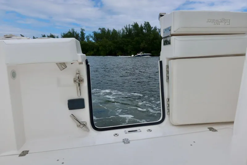 Slide: The Image of 2019 Edgewater 370CC boat with open transom door, view of water and trees. - 35