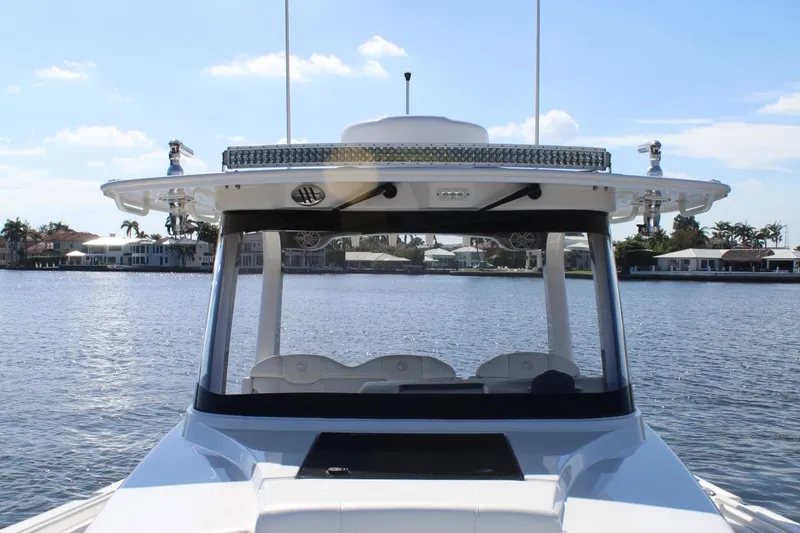 Slide: The Image of 2019 Edgewater 370CC boat on calm water with waterfront homes in background. - 42