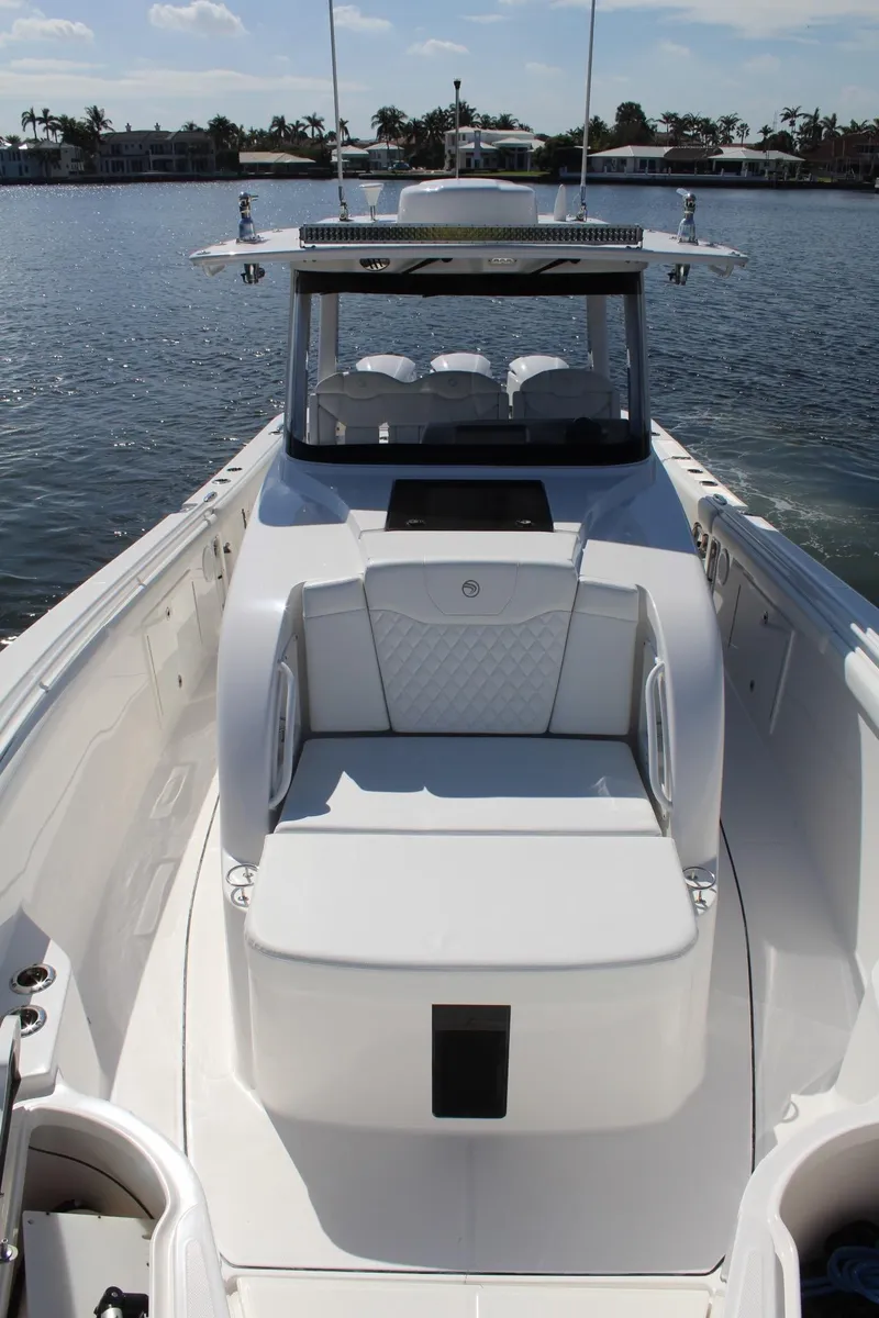 Slide: The Image of 2019 Edgewater 370CC boat on calm water, featuring sleek design and spacious seating. - 44
