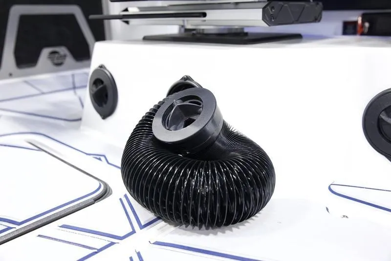 Slide: The Image of 2025 Malibu M242 boat interior with coiled black hose on white surface. - 15