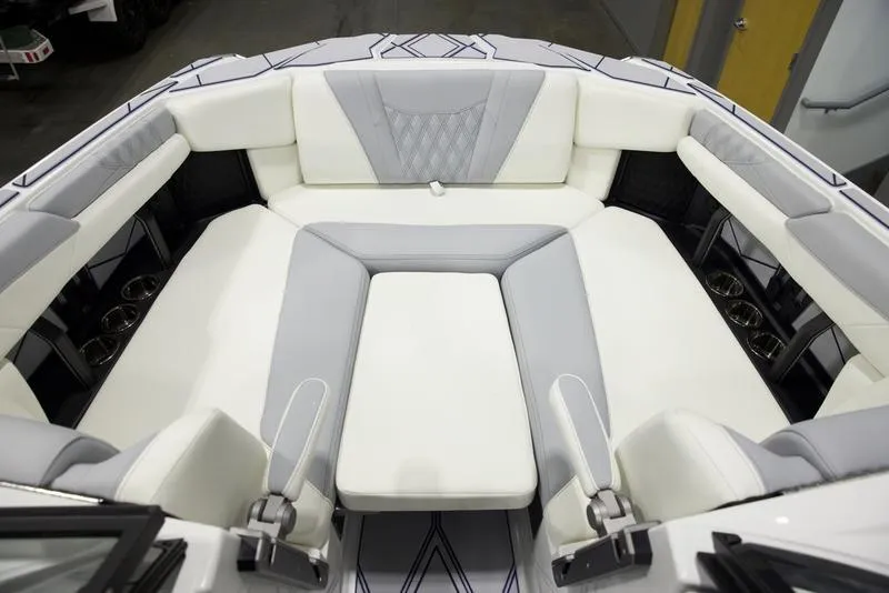 Slide: The Image of 2025 Malibu M242 boat interior with luxurious white and gray seating. - 17