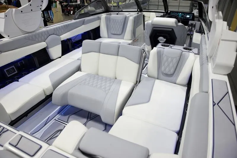 Slide: The Image of 2025 Malibu M242 boat interior with luxurious white and gray seating. - 19