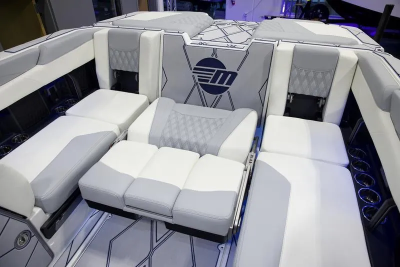 Slide: The Image of 2025 Malibu M242 boat interior with luxurious white and gray seating. - 22