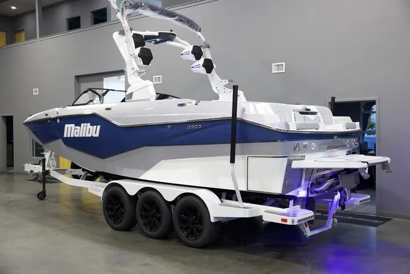 Slide: The Image of 2025 Malibu M242 boat on trailer in showroom. - 4
