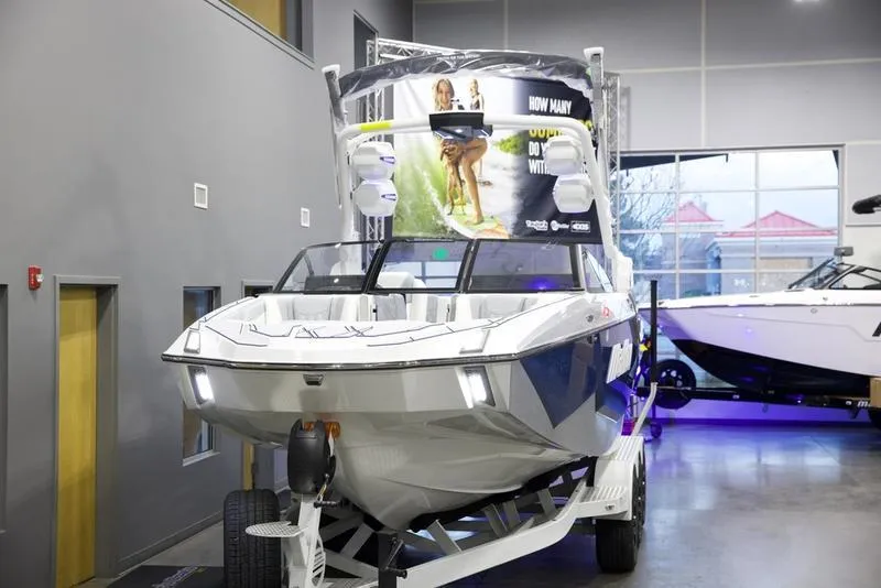 Slide: The Image of 2025 Malibu M242 boat displayed indoors on a trailer. - 9