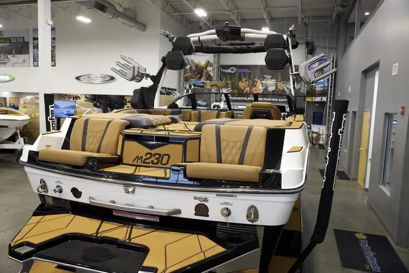 Slide: The Image of 2025 Malibu M230 boat with luxurious seating in a showroom. - 11
