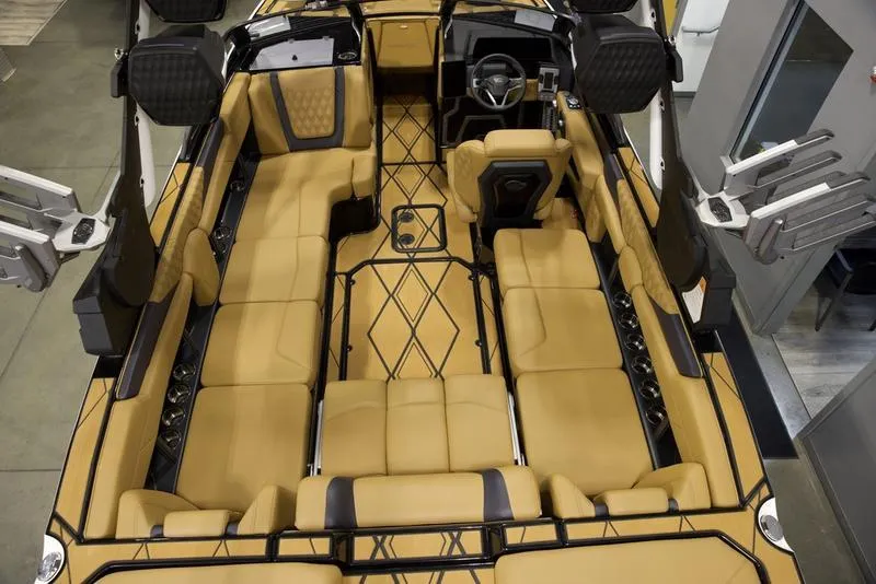 Slide: The Image of 2025 Malibu M230 boat interior with tan seating and modern design. - 12