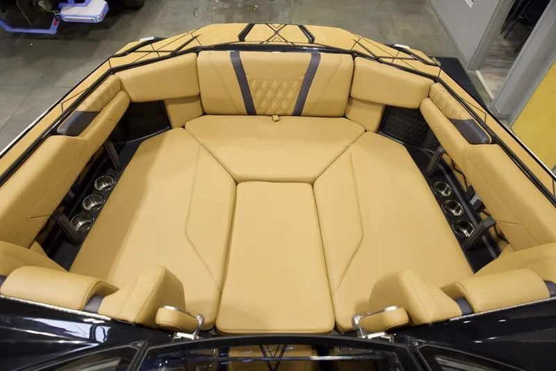 Slide: The Image of Luxurious interior of 2025 Malibu M230 boat with tan seating and cup holders. - 21
