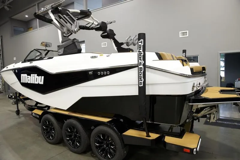 Slide: The Image of 2025 Malibu M230 boat on trailer in showroom, featuring sleek design and modern equipment. - 5