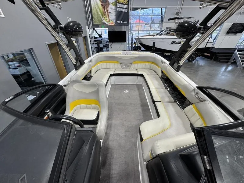 Slide: The Image of 2013 Malibu Wakesetter 24 MXZ interior with white and yellow seating in showroom. - 17