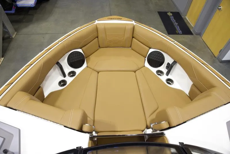 Slide: The Image of 2025 Malibu 23 LSV boat interior with tan seating and built-in speakers. - 15