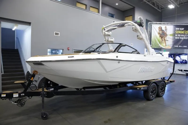 Slide: The Image of 2025 Malibu 23 LSV boat displayed indoors on a trailer. - 3