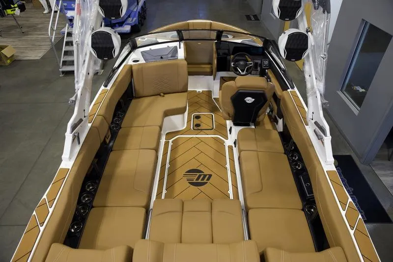 Slide: The Image of 2025 Malibu 23 LSV boat interior with tan seating and modern design. - 9