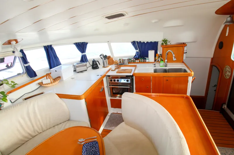 Slide: The Image of Interior of 2002 Lagoon 410 catamaran with modern kitchen and seating area. - 12