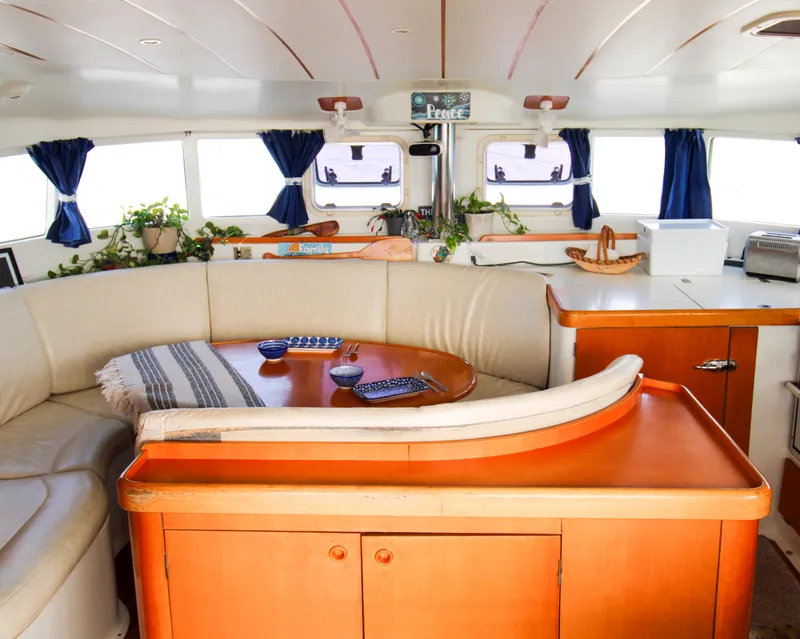 Slide: The Image of Interior of 2002 Lagoon 410 catamaran with cozy seating and nautical decor. - 15
