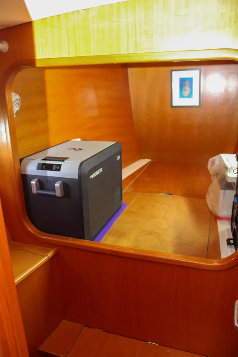 Slide: The Image of Interior of 2002 Lagoon 410 yacht with wooden paneling and compact appliances. - 19