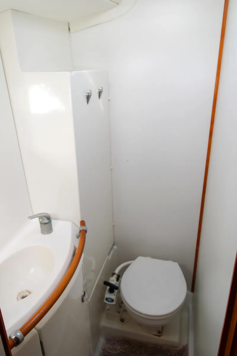Slide: The Image of Compact bathroom in 2002 Lagoon 410 yacht with sink and toilet. - 26