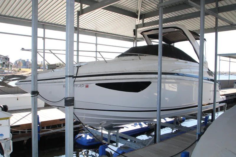 The Image of 2022 Regal 28 Express boat docked in a covered marina. - 0