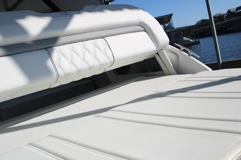 Slide: The Image of 2022 Regal 28 Express boat with white leather seating, docked by the water. - 12