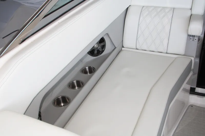 Slide: The Image of 2022 Regal 28 Express boat interior with white seating and cup holders. - 15
