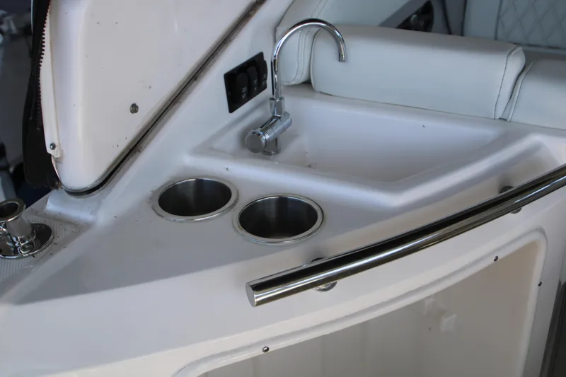 Slide: The Image of 2022 Regal 28 Express boat interior with sink and cup holders. - 2