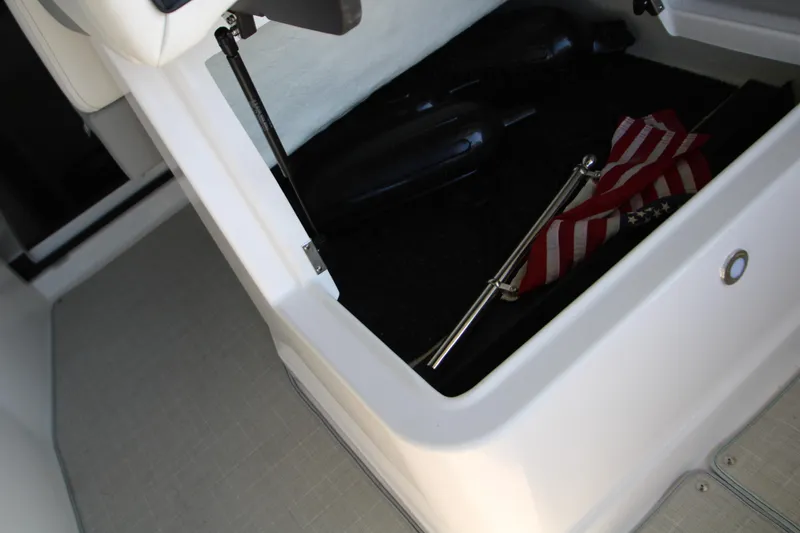 Slide: The Image of 2022 Regal 28 Express boat storage compartment with flag and accessories. - 20