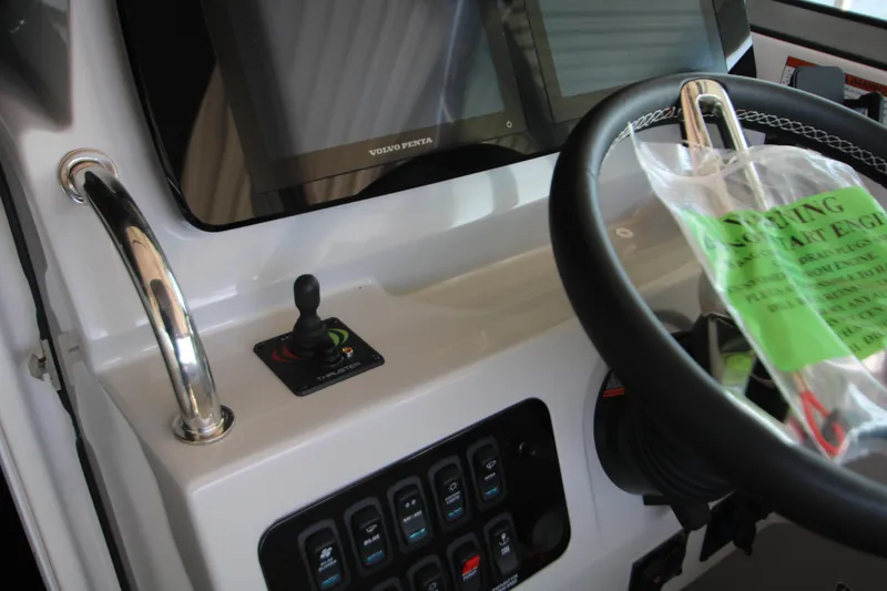 Slide: The Image of 2022 Regal 28 Express boat dashboard with steering wheel and control panel. - 23