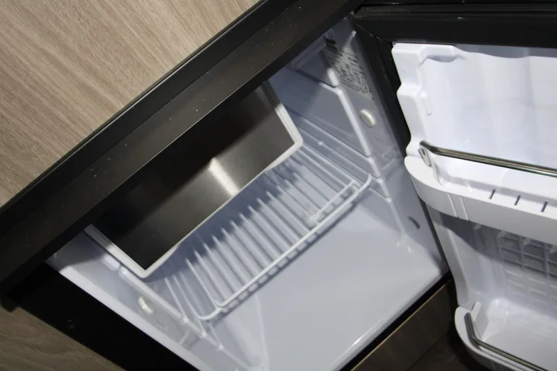 Slide: The Image of 2022 Regal 28 Express boat refrigerator interior, open and empty. - 38
