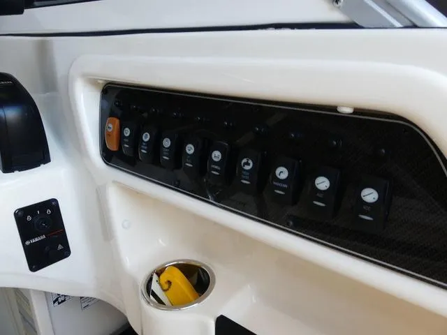 Slide: The Image of Control panel of 2022 Grady-White Adventure 208 boat with switches and cup holder. - 11