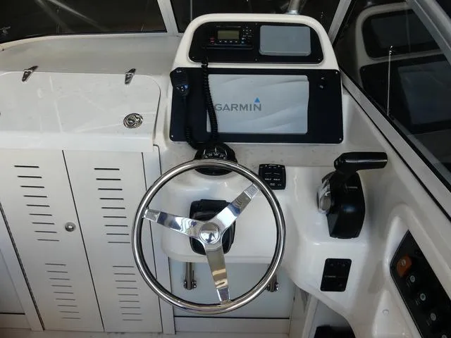 Slide: The Image of 2022 Grady-White Adventure 208 boat dashboard with Garmin navigation system and steering wheel. - 13
