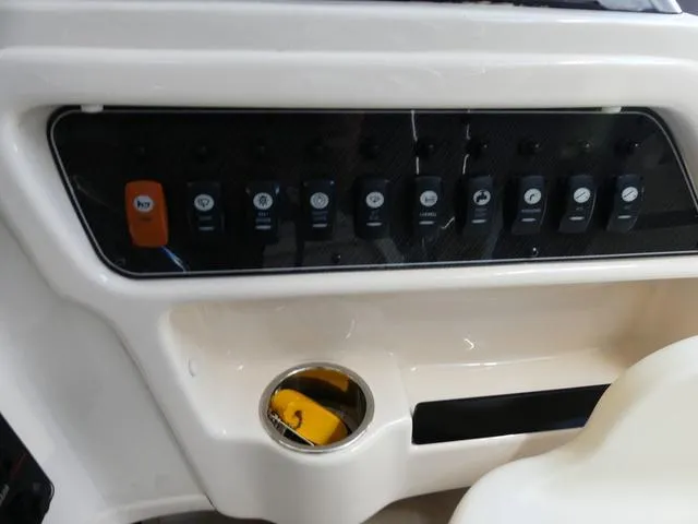 Slide: The Image of Control panel of 2022 Grady-White Adventure 208 boat with switches and cup holder. - 15